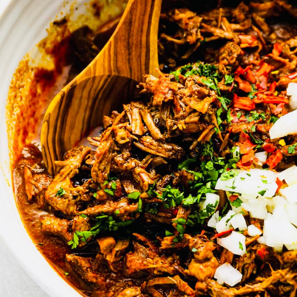 Close-up of Cielito Lindo's shredded Mexican barbacoa with cilantro, diced onions, and red chili flakes.